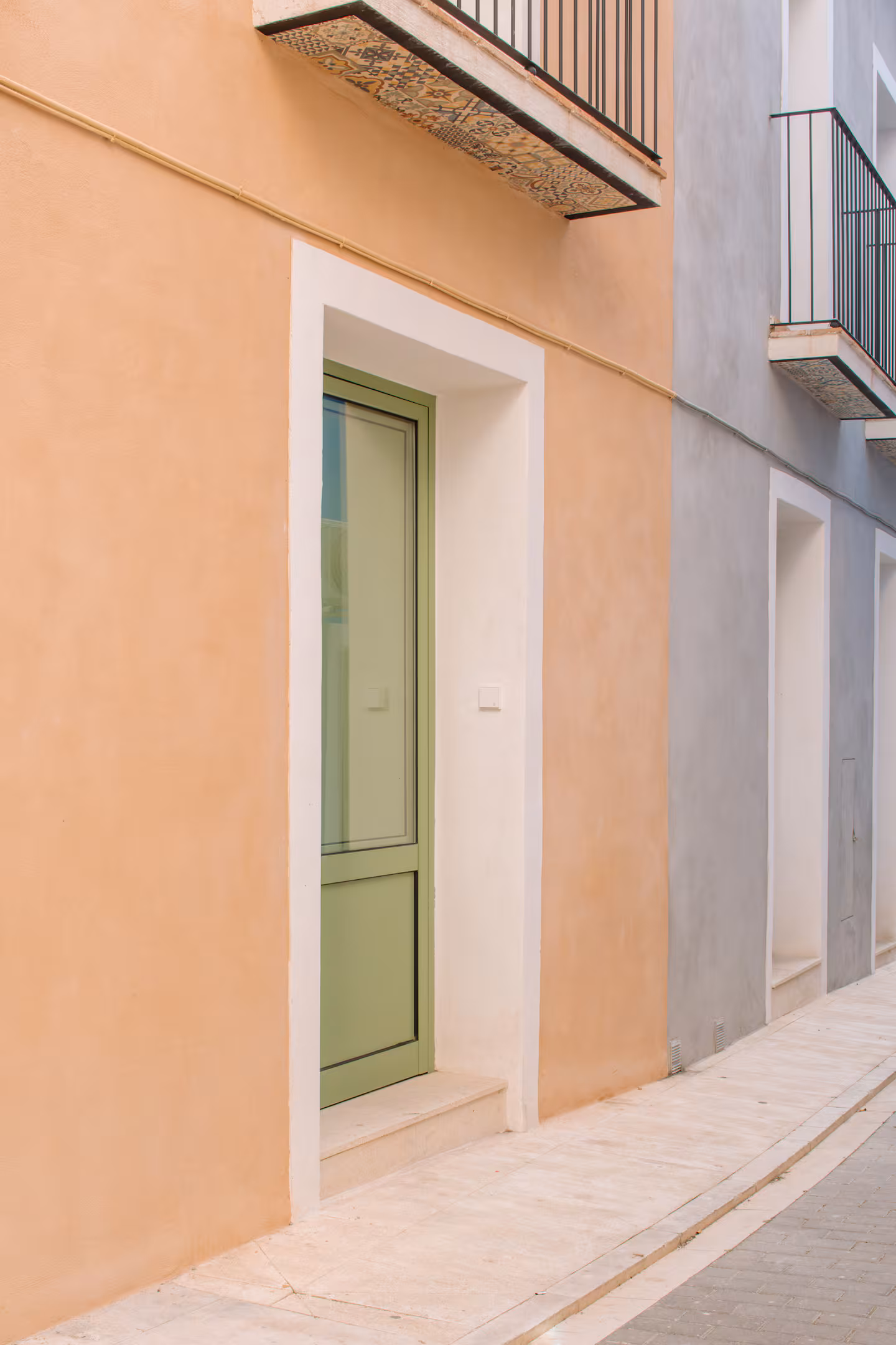 Fachada de la casa con puerta verde en una calle estrecha del casco antiguo de Villajoyosa