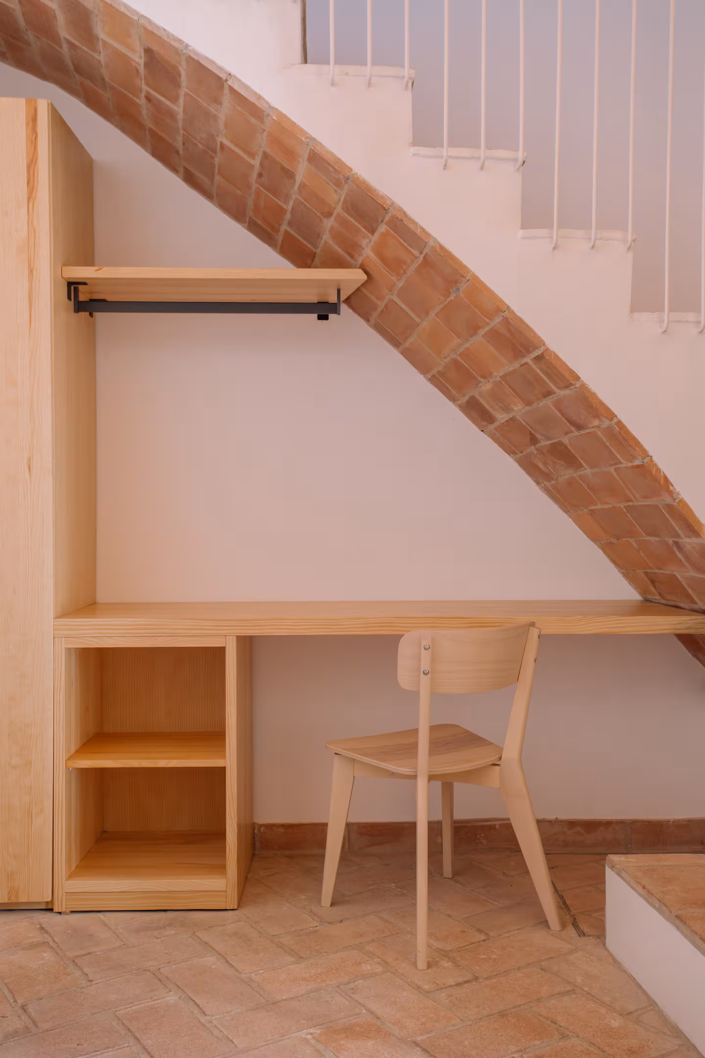 Escritorio de madera bajo el arco de ladrillo de la escalera