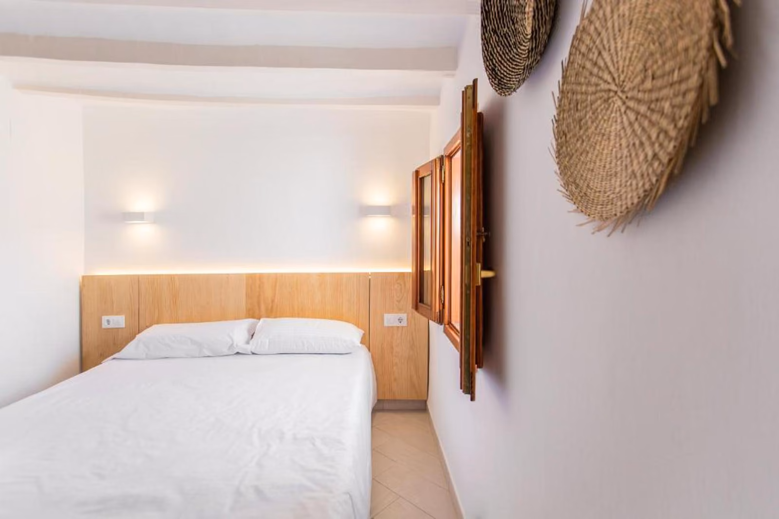 Dormitorio de Mayor 7 con contraventanas de madera y cestos de fibra